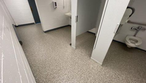 Bathroom with stalls, sinks, toilets and floor with pebble beach coatings
